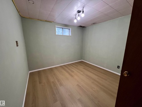 Wood-finish flooring with white trim and light green walls - 15003 81 Street Nw, Edmonton, AB 