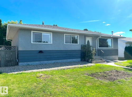 Bungalow exterior with a gray stucco finish and a contrasting dark gray lower facade - 15003 81 Street Nw, Edmonton, AB 