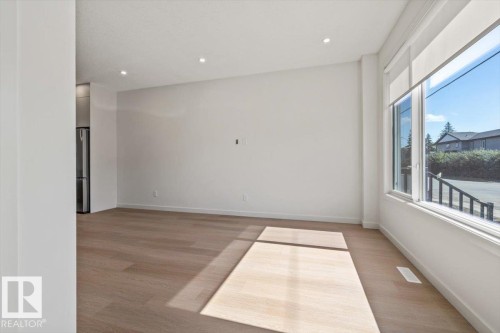 Recessed lighting, wood-finish flooring, and expansive windows with roller shades - 15020 90 Avenue Northwest, Edmonton, AB 