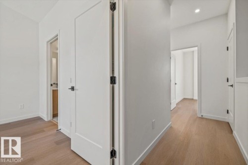 Light wood-finish flooring throughout, white walls, and recessed lighting - 15020 90 Avenue Northwest, Edmonton, AB 