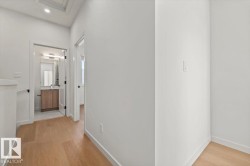 Wood-finish flooring throughout, white walls, and a recessed ceiling light - 