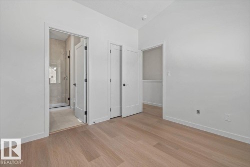 Wood-finish flooring throughout, bright white walls, and a recessed closet space - 15020 90 Avenue Northwest, Edmonton, AB 