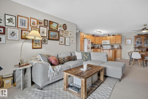 Open-concept living area featuring light-colored carpeting and a contemporary ceiling fan - #335 2096 Blackmud Creek Dr Sw, Edmonton, AB - Indoor Photo Showing Living Room