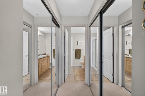 Hallway with mirrored closet doors and carpeted flooring - #335 2096 Blackmud Creek Dr Sw, Edmonton, AB - Indoor