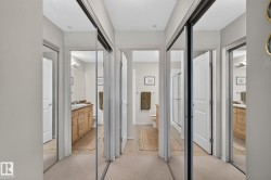 Hallway with mirrored closet doors and carpeted flooring - 