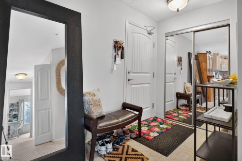 Entryway featuring a white paneled door, built-in mirrored closet, and tile flooring - #335 2096 Blackmud Creek Dr Sw, Edmonton, AB - Indoor Photo Showing Other Room