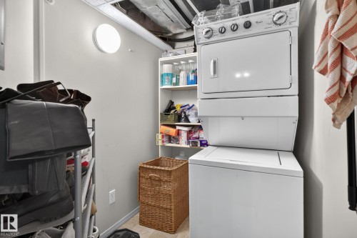 Dedicated laundry area featuring a stacked washer and dryer unit - #335 2096 Blackmud Creek Dr Sw, Edmonton, AB - Indoor Photo Showing Laundry Room