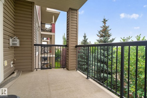 Private balcony with textured flooring, a black metal railing, and siding exterior - #335 2096 Blackmud Creek Dr Sw, Edmonton, AB - Outdoor With Exterior