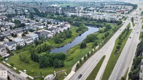 Aerial perspective showcasing a residential area with a prominent natural water feature - #335 2096 Blackmud Creek Dr Sw, Edmonton, AB - Outdoor With View