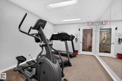 Fitness room featuring an elliptical machine, treadmill, mirrored wall, and carpet flooring - 