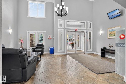 Spacious entryway featuring a high vaulted ceiling, large transom windows, and ceramic tile flooring - #335 2096 Blackmud Creek Dr Sw, Edmonton, AB - Indoor