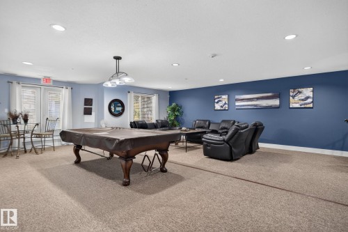 Spacious recreation room featuring neutral carpeting and recessed lighting - #335 2096 Blackmud Creek Dr Sw, Edmonton, AB - Indoor Photo Showing Other Room