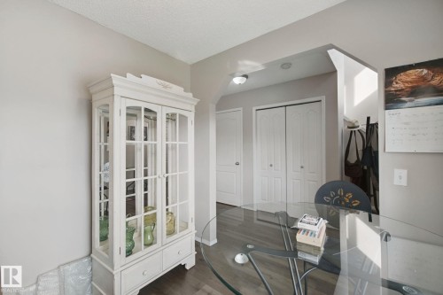 Wood-finish flooring throughout, with a built-in display cabinet featuring glass doors and drawer storage - 15618 141 Street Nw, Edmonton, AB 