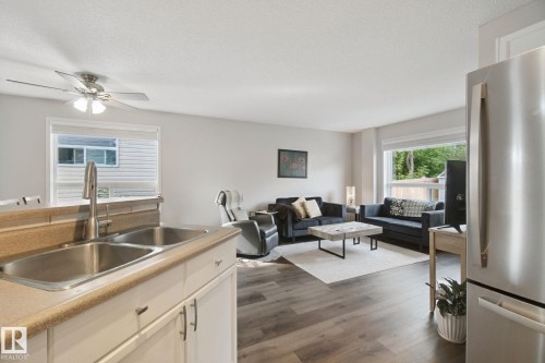 Wood-finish flooring, recessed lighting, and a stainless steel refrigerator - 15618 141 Street Nw, Edmonton, AB 