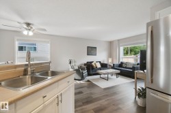 Wood-finish flooring, recessed lighting, and a stainless steel refrigerator - 