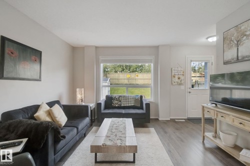 Hardwood-finish flooring, light neutral wall tones, rear yard access, and a large window with natural light - 15618 141 Street Nw, Edmonton, AB 