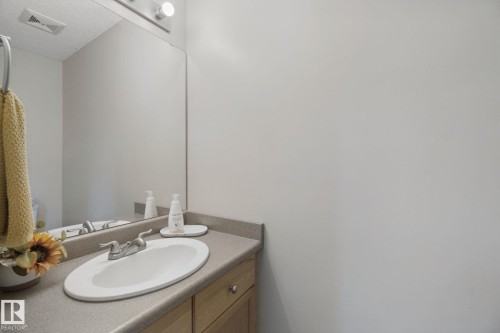 Vanity with an integrated oval sink, chrome faucet, and expansive wall mirror - 15618 141 Street Nw, Edmonton, AB 