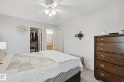 Ceiling fan, wall-mounted television bracket, and carpeted flooring - 