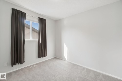 Light gray wall paint with white trim, gray carpeting, and a white-framed window - 15618 141 Street Nw, Edmonton, AB 