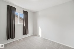 Light gray wall paint with white trim, gray carpeting, and a white-framed window - 