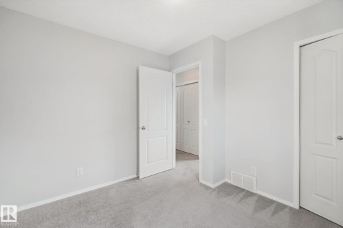 Plush carpeting, light-toned wall finishes, crisp white trim, and a white interior door - 15618 141 Street Nw, Edmonton, AB 