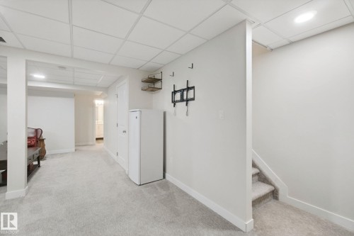 Carpeted flooring, drop ceiling, recessed lighting, and a white interior door - 15618 141 Street Nw, Edmonton, AB 