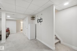 Carpeted flooring, drop ceiling, recessed lighting, and a white interior door - 