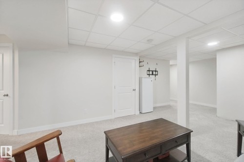 Spacious finished basement with neutral drywall, recessed ceiling lighting, and light-colored concrete flooring - 15618 141 Street Nw, Edmonton, AB 