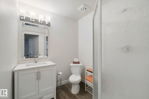 White vanity with brushed nickel hardware, a rectangular undermount sink, and a white countertop - 15618 141 Street Nw, Edmonton, AB 