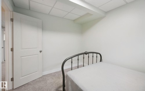 Wall-to-wall carpeting with light-toned walls and a paneled door - 15618 141 Street Nw, Edmonton, AB 
