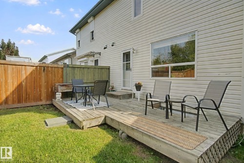 Exterior featuring a wood deck, manicured lawn, and privacy fencing - 15618 141 Street Nw, Edmonton, AB 