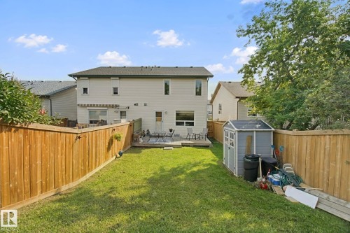 Expansive fenced backyard featuring a grassy lawn, wooden privacy fencing, and a built-in wooden deck - 15618 141 Street Nw, Edmonton, AB 