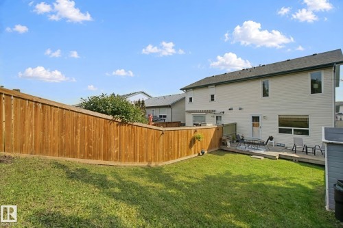 Expansive backyard featuring a wood fence, manicured lawn, and a multi-level wood deck - 15618 141 Street Nw, Edmonton, AB 