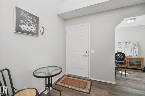 White paneled entry door, light gray wall finishes, recessed entryway, wood-finish flooring, and arched doorway - 15618 141 Street Nw, Edmonton, AB 