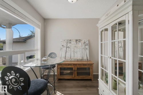 Wood-finish flooring throughout, large window for natural light, and a built-in display cabinet with glass panels - 15618 141 Street Nw, Edmonton, AB 