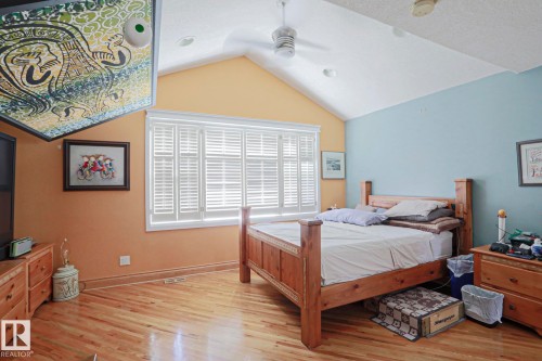 Vaulted ceiling with recessed lighting and a ceiling fan, hardwood flooring, and a large window with plantation shutters - 10814 125 Street Nw, Edmonton, AB 
