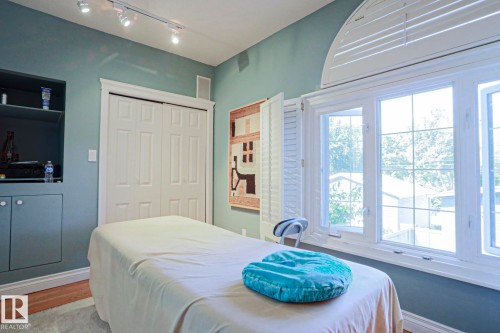Room with track lighting, an arched top window, and built-in cabinetry - 10814 125 Street Nw, Edmonton, AB 