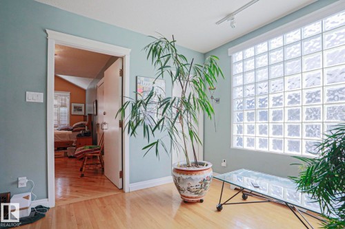 Light wood-finish flooring, glass block window, light blue wall paint, white trim, and track lighting - 10814 125 Street Nw, Edmonton, AB 