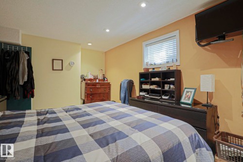 Recessed ceiling lighting, window with blinds, wall-mounted television bracket, open closet with hanging rod, and light-toned wall finishes - 10814 125 Street Nw, Edmonton, AB 