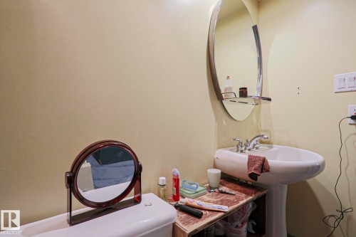 Pedestal sink with dual-handle faucet and oval mirror - 10814 125 Street Nw, Edmonton, AB 