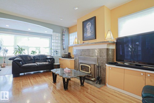 Hardwood flooring throughout, recessed ceiling lighting, built-in display shelving, and an arched entryway - 10814 125 Street Nw, Edmonton, AB 