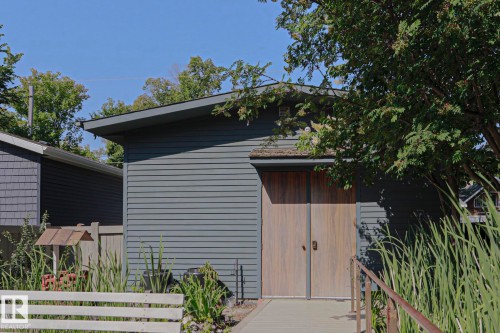 Gray horizontal siding with natural wood-finish double doors - 10814 125 Street Nw, Edmonton, AB 