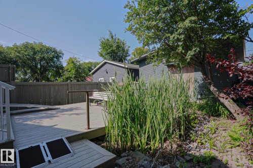 Expansive outdoor decking, mature trees, privacy fencing, and established plantings - 10814 125 Street Nw, Edmonton, AB 