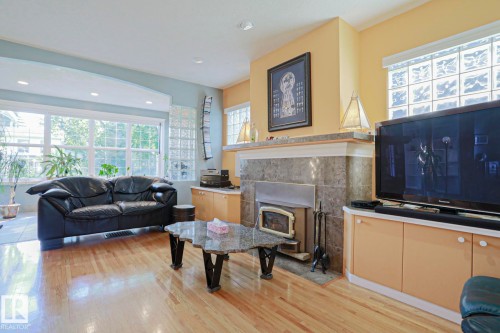 Hardwood flooring throughout, large windows, recessed ceiling lighting, built-in fireplace, and glass block windows - 10814 125 Street Nw, Edmonton, AB 