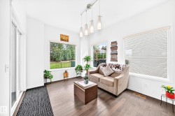 Hardwood-finish flooring, white walls, multiple large windows, sliding glass door, and track lighting with pendant fixtures - 