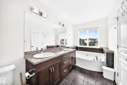 Dual vanity with undermount sinks, mosaic tile backsplash, and dark wood-finish cabinetry - 
