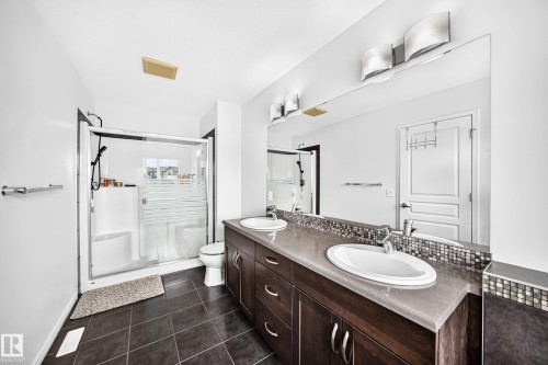 Dual vanity with undermount sinks, spacious countertop, and mosaic tile backsplash - 2015 Chalmers Way Sw, Edmonton, AB 