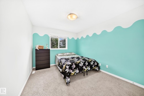 Plush carpet flooring, a window offering natural light, and a ceiling-mounted light fixture - 2015 Chalmers Way Sw, Edmonton, AB 
