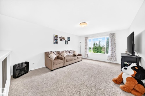 Recessed ceiling light fixture, white painted walls, large window with outdoor scenery, light-colored carpet flooring, white trim - 2015 Chalmers Way Sw, Edmonton, AB 