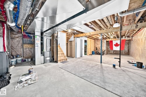 Unfinished basement with concrete flooring, exposed wooden joists, and visible utility systems - 2015 Chalmers Way Sw, Edmonton, AB 